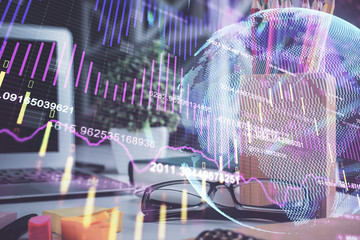 Financial chart hologram with glasses on the table background. Concept of business. Double exposure.