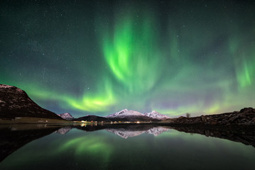 Fototapeta na wymiar Northern lights with mountain reflection