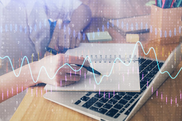 Financial charts displayed on woman's hand taking notes background. Concept of research. Double exposure