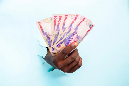 black hand holding some naira notes