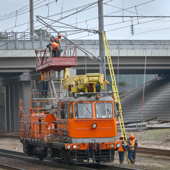 Special train with lifting platform for maintenance and repair electrical line on railway. Group of workers fulfill the maintenance of electric networks over the rails. Workers repairing power wires