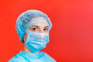 Portrait of a woman wearing medical uniform and mask with infection text at red background. Coronavirus concept. Protect your health concept with copy space