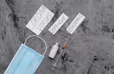 Syringe, vaccine, protective mask and paper with an inscription Coronavirus.