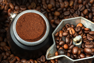 Close-up of an open Italian coffee maker with ground coffee in the metal filter, on many roasted...