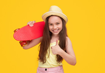 Joyful girl with skateboard showing thumb up