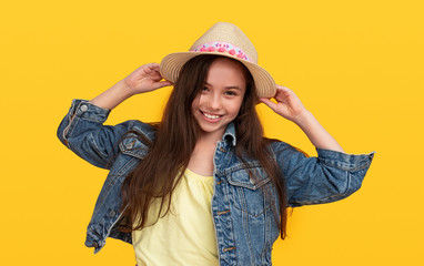 Happy fashionable preteen girl on yellow background