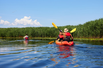 Couple kayaking on river together. Having fun in leisure activity. Romantic and happy woman and man on the kayak. Sport, relations concept.