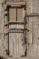 front view of door to abandoned warehouse, old wooden door of a warehouse or a barn, vintage old warehouse wooden gate, wooden texture or background