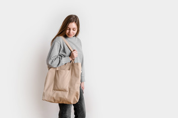 Young woman with canvas shopping bag. Eco friendly lifestyle. Isolated white background