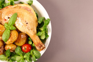 grilled chicken leg with roasted potato and lettuce