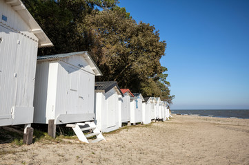 Fototapeta na wymiar Cabines blanches sur la plage des Sableaux à Noirmoutier en l'île (Vendée, France)