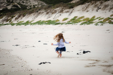 Little girl playing on beach at Portland, Victoria Australia