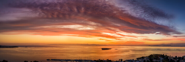 Fototapeta na wymiar Panorama eines Sonnenunterganges über dem Meer mit roten und violetten Farben