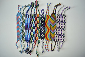 Multicolored friendship bracelets with different patterns handmade of embroidery floss and thread...