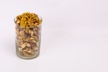A glass of walnuts. Peeled nuts on a white background.