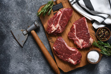 Raw beef steak beef steak on a wooden board with an ax.