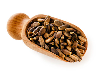 Seed of a Milk Thistle (Silybum marianum) known as Scotch Thistle or Marian Thistle in wooden scoop isolated on a white background.