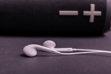 Close-up headphone stack on black background, modern speaker earbuds device accessories.