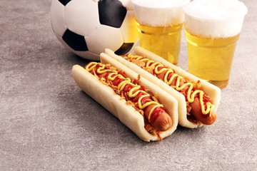 Grilled hot dogs with mustard and ketchup on the table with draft beer for football soccer party...