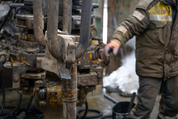 Offshore oil rig worker prepare tool and equipment for perforation oil and gas well at wellhead platform. Making up a drill pipe connection. A view for drill pipe connection from between the stands.