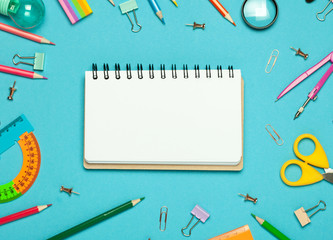 Colorful pink background with various School accessories and stationery are laid out in the form of a rainbow. Empty notebook, mock up. Flat lay top view.