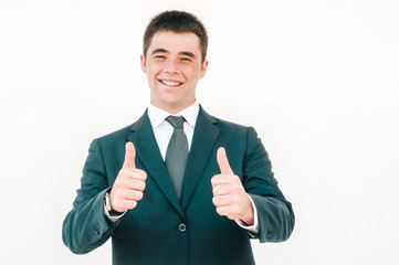 Cheerful young professional expressing approval. Young man in office jacket and tie showing thumbs up and smiling at camera. Like gesture or approval concept