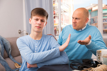 Obraz premium Father scolding his turned away son