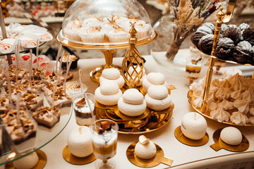 Candy bar. Table with different sweets for party. Delicious sweet buffet with cupcakes. Sweet holiday buffet with cupcakes and other desserts.