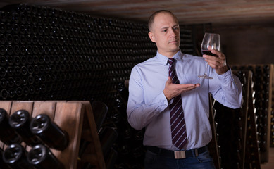 Sommelier tasting red wines in winery basement