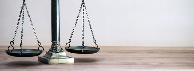 Law scales on wooden desk concept for justice and equality