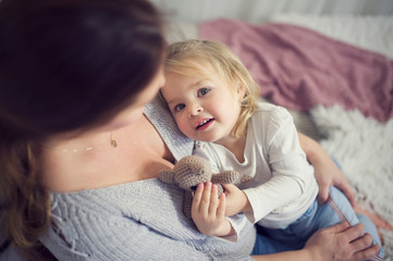 Little baby lies on mum and looks at her. Common moments mother and her daughter little girl