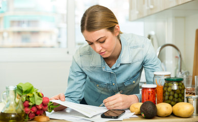 Woman counting money for paying bills at kitchen
