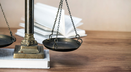 Law scales on wooden desk concept for justice and equality