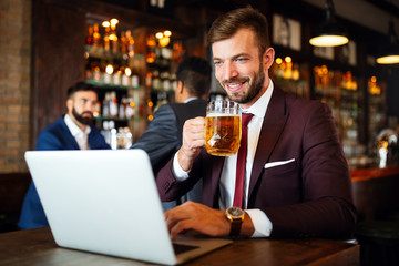 Portrait of a successful business man sitting at the cafe working on a laptop.