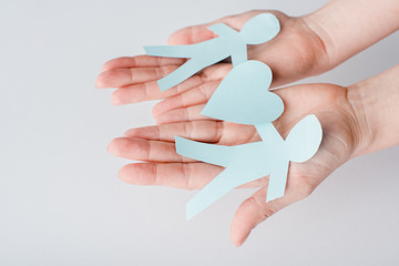 cropped view of woman holding figures of people cut from paper with heart, human rights concept