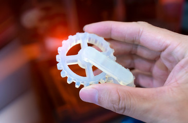 hand with Object of gear printed on 3d printer close-up
