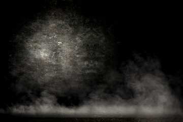 Desk of free space and black background with smoke decoration. 