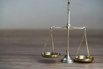 Law scales on wooden desk concept for justice and equality