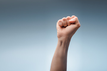 Cropped view of man with clenched fist on grey, human rights concept