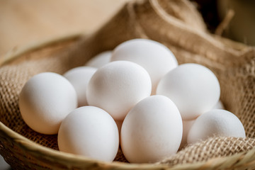 Chicken eggs in basket on table.