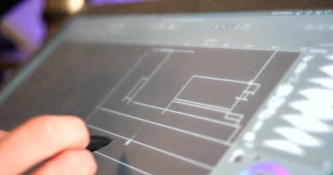 An architect sketching and drafting out blueprints for a building project on a digital graphic tablet in a design studio.