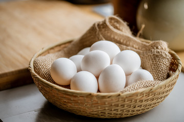 Chicken eggs in basket on table.