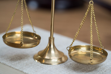 Law scales on wooden desk concept for justice and equality