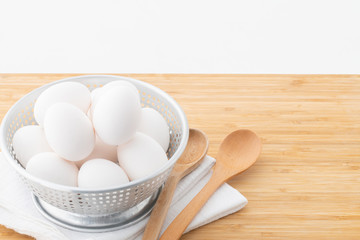 Chicken eggs in basket on table. © Tsurukame Design