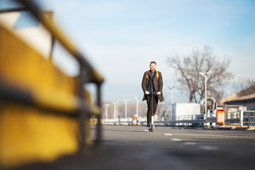 Young businessman on e scooter in the city