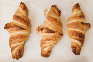 Newly baked croissants on white paper background