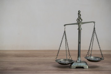 Law scales on wooden desk concept for justice and equality