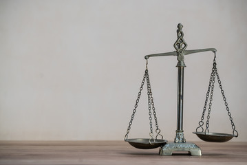 Law scales on wooden desk concept for justice and equality