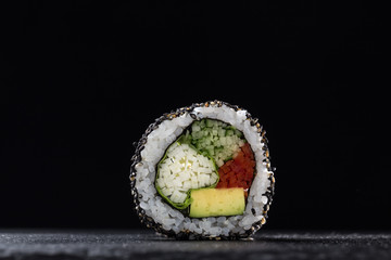 Sushi Rolls with vegetables on a dark background. Sushi set on a stone plate and dark concrete background. Sushi roll set and chopsticks. Fresh Japanese cuisine. asian food. Sushi image for menu. clos