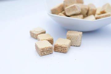 Chocolate cube wafers served in a bowl isolated on white background